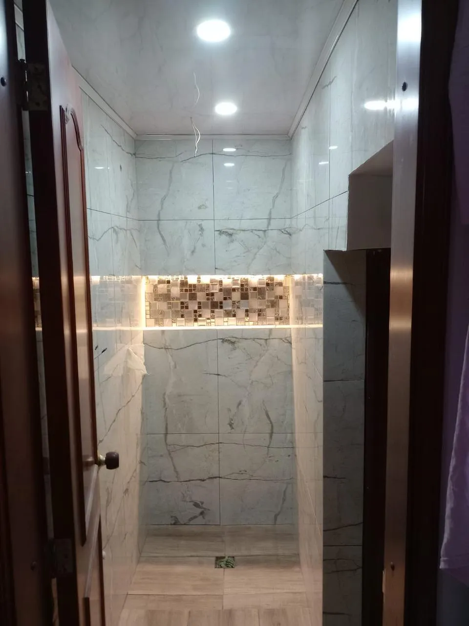 Ducha enchapada en porcelánico con cenefa iluminada
